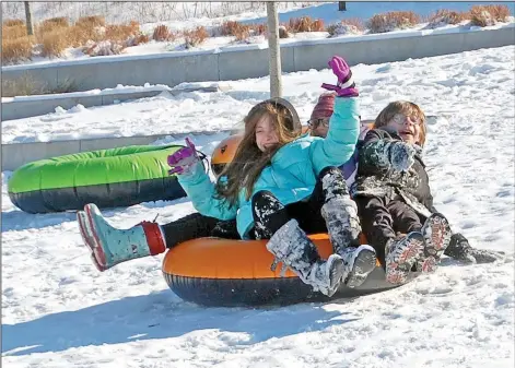  ?? (NWA Democrat-Gazette/Janelle Jessen) ?? Children enjoy sledding in Memorial Park on Thursday in Siloam Springs. The hill was a popular place for sledding throughout the week.