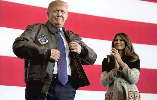  ?? PHOTO AFP ?? Donald Trump a enfilé un blouson d’aviateur avant de s’adresser aux soldats américains de la base de Yokota avec Melania.
