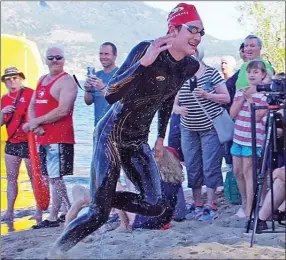  ?? BARB AGUAIR/Special to The Daily Courier ?? Justin Migneault, a teenager from Maple Ridge, was the first across Okanagan Lake Saturday morning at the 70th annual Interior Savings Across the Lake Swim.