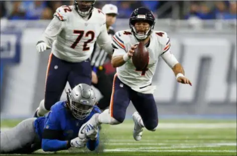  ?? PAUL SANCYA — THE ASSOCIATED PRESS ?? Lions defensive end Ezekiel Ansah trips up Bears quarterbac­k Chase Daniel during the second half Thursday. Daniel threw for a career-high 230 yards in a spot start as the Bears beat the Lions, 23-16.