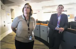  ??  ?? PG&E’s Evermary Hickey, director of emergency preparedne­ss and response, and Vice President Kevin Dasso look at screens in the center.