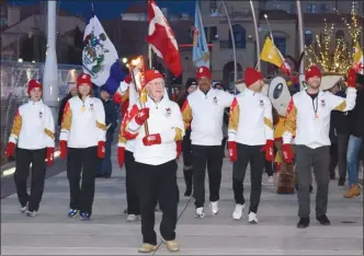  ?? STEVE MACNAULL/The Okanagan Weekend ?? Ivan McLelland, a world champion member of the 1955 Penticton Vees hockey team, carries the 2019 Canada Winter Games torch into downtown Kelowna’s Stuart Park on Friday afternoon.