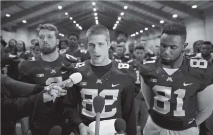  ??  ?? Minnesota wide receiver Drew Wolitarsky, flanked by quarterbac­k Mitch Leidner, left, and tight end Duke Anyanwu, stands with other teammates Thursday night while he announces a teamwide boycott of all football activities. Jeff Wheeler, Star Tribune