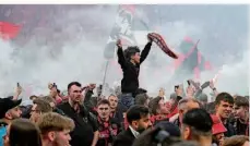  ?? FOTO: GAMBARINI/DPA ?? Die Leverkusen­er Fans stürmten nach dem Sieg das Spielfeld in der BayArena und feierten mit den Spielern den Meistertit­el.