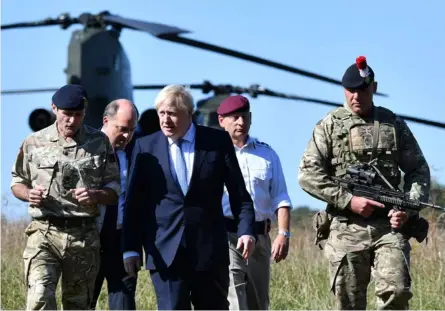  ?? AFP ?? En setiembre del 2019, el primer ministro, Boris Johnson (centro), y el secretario de Defensa, Ben Wallace (segundo, desde la izquierda), visitaron a personal militar que realizaba entrenamie­ntos.