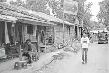  ??  ?? Rafiq walks around the Kutupalong refugee camp in search of content to be recorded with his mobile phone.