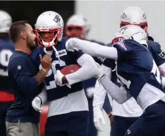  ?? NAncy lAnE pHoToS / HErAld STAFF ?? NEW TO TOWN: Patriots cornerback Shaun Wade runs through a drill during practice at Gillette Stadium on Thursday. At left, running back James White makes a catch during practice.