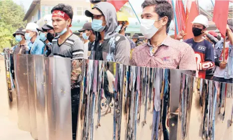  ?? DAWEI WATCH ?? Protesters hold homemade shields Saturday in Dawei, Myanmar, during a demonstrat­ion against a military coup.