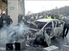  ?? Thibault Camus/Associated Press ?? Demonstrat­ors push a charred car during a protest Saturday in Paris.