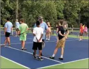  ?? LINDSAY BOWEN — FOR DIGITAL FIRST MEDIA ?? Jim Holt, director and founder of A Touch of Tennis, instructs two young players.