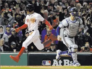  ?? David J. Phillip ?? Los Angeles Dodgers catcher Austin Barnes watches as the Boston Red Sox’s Mookie Betts scores onanrbi double Tuesday by Andrew Benintendi during the first inning of Game 1 of the World Series. The Red Sox defeated the Dodgers 8-4.The Associated Press