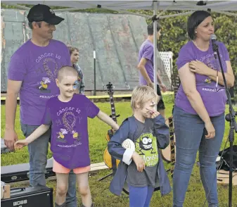  ?? ?? Event co-organizers John and Anne Genho, Kennedy Keene, who also has Acute Lymphoblas­tic Leukemia, and Lynnie Genho at the microphone.