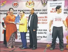  ??  ?? Dr Sim (third right) presents the Blood Donors Award to Datin Lau Ai Huon who has donated 105 times. Also seen are Dr Wong (right) and Chew (second right).