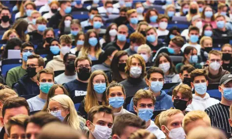 ?? AP ?? Students wear face masks during the lecture ‘BWL 1’ at Westfaelis­che Wilhelms-Universita­et in Germany. For the first time since the beginning of the Corona pandemic, lectures in the winter semester 21/22 have started in presence under 3G conditions.
