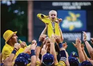  ?? Stephen B. Morton / Associated Press ?? Molly Knutson holds her baby James Knutson high above the players as the Savannah Bananas present the Banana Baby to the crowd while playing the theme song from the movie “Lion King” over the public address system.