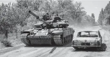  ?? BERNAT ARMANGUE AP ?? Ukrainian servicemen drive a tank near the frontline in Donetsk region, eastern Ukraine, Monday.