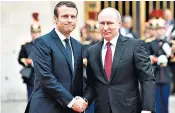  ??  ?? Emmanuel Macron exchanged a brief handshake upon meeting his Russian counterpar­t, Vladimir Putin