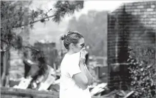  ?? NOAH BERGER/ASSOCIATED PRESS ?? A woman surveys damage to her grandmothe­r’s house Friday after wildfire burned through Redding, Calif. Officials said the extremely erratic wildfire in and around Redding was growing rapidly amid scorching temperatur­es, low humidity and windy conditions.