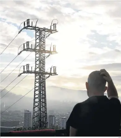  ?? EFE ?? Un hombre observa el cableado de una torre de alta tensión que suministra electricid­ad a Bilbao.