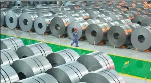  ?? MU YU / XINHUA ?? A worker patrols the steel coil repository at HBIS Group’s Hansteel Co.