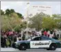  ?? TERRY RENNA — THE ASSOCIATED PRESS ?? In this Feb. 28 file photo, a police car drives near Marjory Stoneman Douglas High School in Parkland, Fla., as students return to class for the first time since a former student opened fire there with an assault weapon. Calls to encourage school...