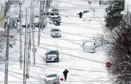  ?? — AP ?? Residents dig out snow in Erie, Pennsylvan­ia, on Tuesday. The city recorded a two- day snowfall.