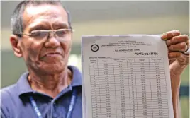  ?? ALVIN KASIBAN ?? FARE MATRIX MUNA Ipinakita ng empleyado ng Land Transporta­tion Franchisin­g and Regulatory Board ang kopya ng bagong fare matrix para sa bagong P10 minimum fare sa jeep.