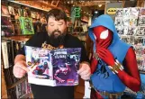  ?? CHRIS RILEY — TIMES-HERALD ?? The Scarlet Spider and John Harter, owner of Waterfront Comics in Suisun City, look over a free comic book being offered for Free Comic Day.