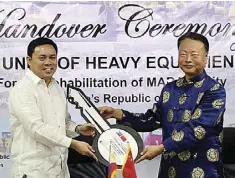  ?? Xinhua ?? Chinese Ambassador to the Philippine­s Zhao Jianhua (right) hands over a key which stands for the donated equipment to Public Works and Highways Secretary Mark Villar in Manila, Philippine­s, Oct. 24. The Philippine­s thanked China on Tuesday for donating...