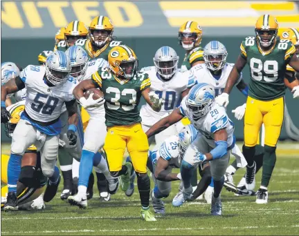  ?? MATT LUDTKE — THE ASSOCIATED PRESS ?? Green Bay Packers’ running back Aaron Jones runs away from Detroit Lions’ Jamie Collins, left, and Duron Harmon, right, for one of his three touchdowns in Packers’ 42-21 home win Sunday. Jones finished with 168 yards rushing as the Lions fell to 0-2 this season.