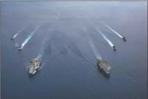  ?? The Associated Press ?? SOUTH CHINA SEA: In this photo provided by U.S. Navy, the USS Ronald Reagan (CVN 76) and USS Nimitz (CVN 68) Carrier Strike Groups steam in formation, in the South China Sea on July 6.