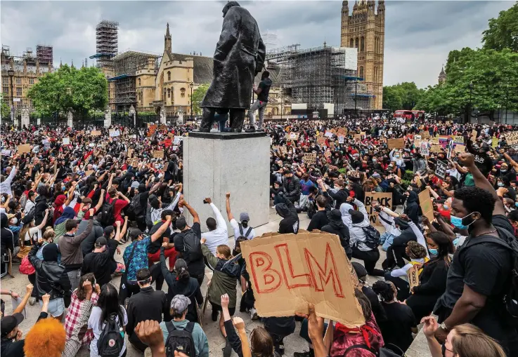  ??  ?? of whom brought placards reading Black Lives Matter, or BLM – raise their fists in solidarity with US demonstrat­ors in the shadow of the Houses of Parliament