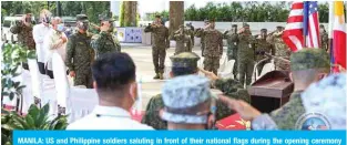  ?? AFP ?? MANILA: US and Philippine soldiers saluting in front of their national flags during the opening ceremony of the annual joint military exercise at the main military base in Manila Monday.—