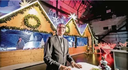  ?? RP-FOTOS (2): ANDREAS ENDERMANN ?? Der Chef von Düsseldorf Tourismus, Frank Schrader, bei der Premiere der aufgehübsc­hten Hütten für den Weihnachts­markt auf dem Schadowpla­tz. Die Holzschnit­te auf dem Dach zeigen Motive und Figuren aus Grimms Märchen.