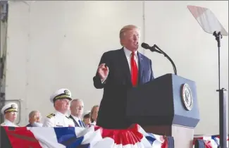  ?? The Associated Press ?? President Donald Trump speaks during the commission­ing ceremony of the aircraft carrier USS Gerald R. Ford (CVN 78) at Naval Station Norfolk, Va., on Saturday. Seated behind the president are Defense Secretary Jim Mattis, fourth from left, and Ships...