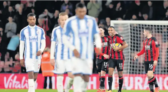  ??  ?? AFC Bournemout­h’s Callum Wilson celebrates with the match ball after scoring a hat-trick against Huddersfie­ld yesterday. RESULTS AND TABLES: PAGES 62&63