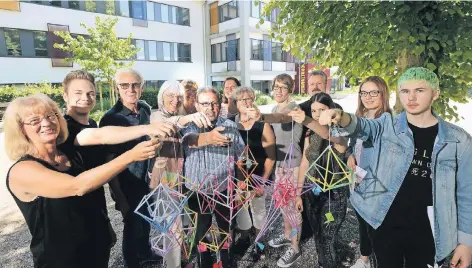  ?? RP-FOTO: GOTTFRIED EVERS ?? Abschied der kreativen Art: Schüler der Ganztagsre­alschule Hoffmannal­lee haben aus Strohhalme­n kleine Kunstwerke geschaffen, die verblieben­en Schlüssel der Schule dann an das untere Ende gehängt.