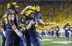  ?? TONY DING — THE ASSOCIATED PRESS ?? Michigan running back Blake Corum (2) celebrates a touchdown with teammates against Washington on Sept. 11.