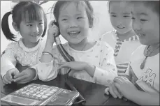  ?? MA FENGCHENG / FOR CHINA DAILY ?? Children use a landline phone in a kindergart­en in Chaohu, Anhui province.