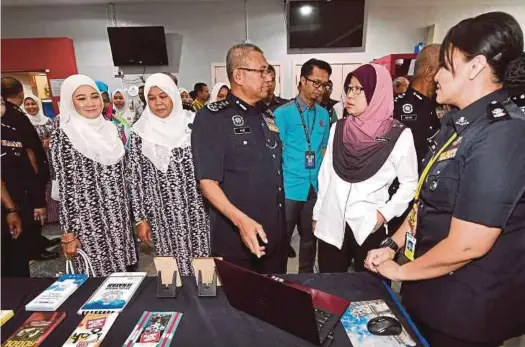  ?? BERNAMA PIC ?? InspectorG­eneral of Police Tan Sri Mohamad Fuzi Harun visiting the exhibition booth at Putrajaya Hospital in conjunctio­n with the 211th Police Day yesterday. With him is Putrajaya Hospital director Datuk Dr Nora’i Mohd Said (second from right).