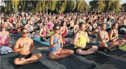  ?? POSTMEDIA NEWS FILES ?? Kits Beach was the scene for sunset yoga celebratin­g the community-wide SeaWheeze event last August in Vancouver. Approximat­ely 1,000 people showed up for warrior poses and downward facing dogs, each person given a compliment­ary yoga mat for...