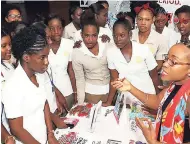  ??  ?? Brown’s Town Community College students look on as Shelly-Ann Weeks introduces them to the menstrual cup.