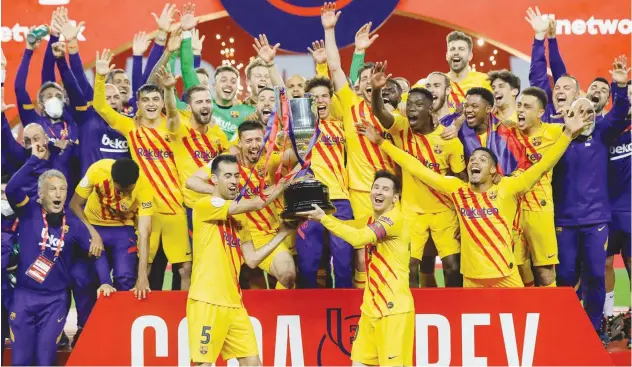  ?? Agence France-presse ?? ↑
Barcelona players celebrate with the trophy after winning the Copa del Rey final against Athletic Bilbao in Seville on Saturday.