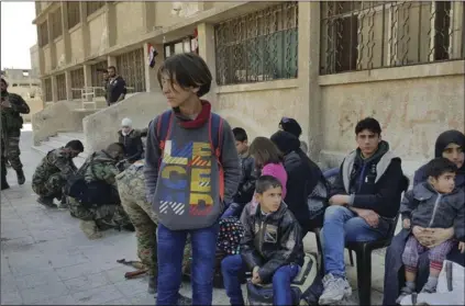  ??  ?? This photo released by the Syrian official news agency SANA, shows Syrian civilians, who fled fighting between the Syrian government forces and rebels, at an army checkpoint, in eastern Ghouta, a suburb of Damascus, Syria, on Tuesday. The Syrian...