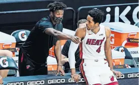  ?? [AP PHOTO/MARTA LAVANDIER] ?? Heat forward KZ Okpala (4) listens to teammate Jimmy Butler during the first half against the Nuggets on Wednesday in Miami. Butler has missed multiple games because of the NBA's health and safety protocols.