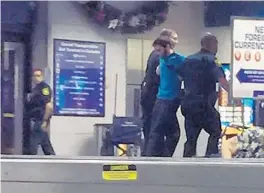 ?? FILE/COURTESY OF MARK LEA ?? Broward sheriff ’s deputies take Esteban Santiago into custody soon after the shooting at Fort Lauderdale-Hollywood Internatio­nal Airport. He killed five people and injured six.