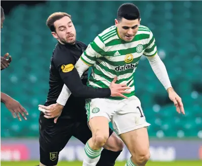  ??  ?? Going nowhere Livingston’s Scott Pittman gets to grips with Celtic’s Tom Rogic