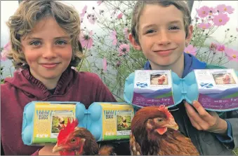  ??  ?? Henny and Charlie Jones holding the egg boxes on which they feature. Henny, left, with two boxes of Kintyre Eggs, and Charlie, right, shows off the new Deliciousl­y Scottish Eggs packaging.