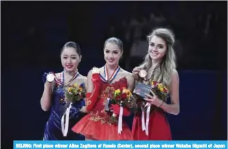  ?? — AFP ?? BEIJING: First place winner Alina Zagitova of Russia (Center), second place winner Wakaba Higuchi of Japan (L) and third place winner Elena Radionova of Russia(R) show their medals.