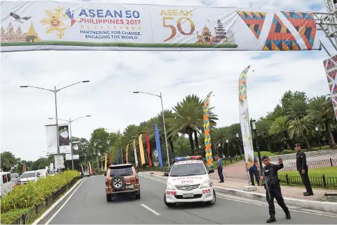  ?? — AFP photo ?? An armed policeman stands guard at the entrance to the venue of the Associatio­n of Southeast Asia Nations (Asean) Regional Forum (ARF) meeting in Manila.